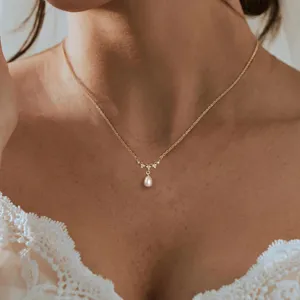 Elegante goldene Halskette mit tropfenförmigem Perlenanhänger und feinen Kristallakzenten