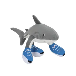 Simpatico peluche a forma di squalo con scarpe blu su sfondo bianco, bambola morbida