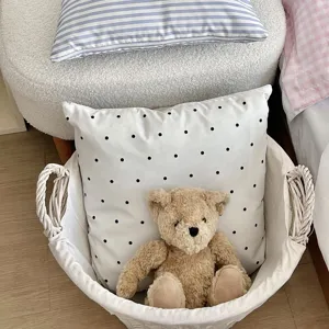 Cozy aesthetic pillowcase detail scene featuring polka dot cushion in white fabric laundry basket.