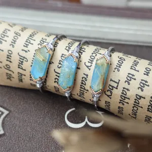 Close-up view of three silver rings with turquoise and rutilated quartz on vintage paper.