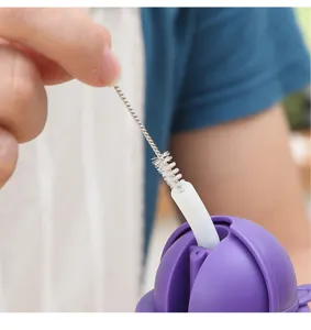 Détail macro d'une mini brosse nettoyant un bec verseur étroit