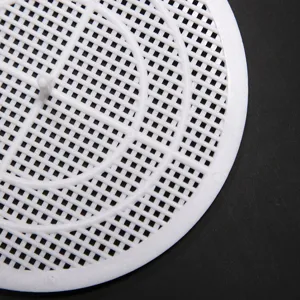 Dettaglio ravvicinato di un filtro a rete in plastica bianca ritagliabile per scarichi.