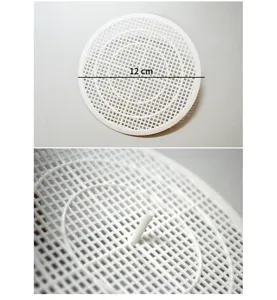 Primo piano di un filtro per scarico a pavimento in rete plastica bianca da 12 cm per lavelli