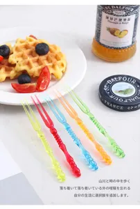 Close-up of colorful Japanese-style plastic fruit forks arranged on a breakfast table