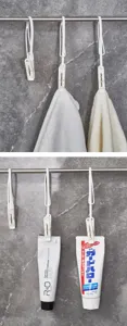 Weiße Wäscheklammern aus Kunststoff für Handtücher und Zahnpasta an einer Metallschiene