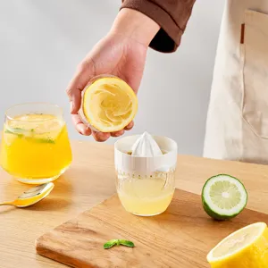 Portable manual citrus juicer for oranges and lemons with a measuring cup in kitchen