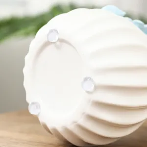 Weiße Keramikbasis mit drei transparenten rutschfesten Gummipads für Möbelschutz