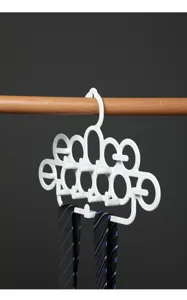 Dichtbij van een witte multifunctionele stropdas- en riemhanger organizer aan houten stang