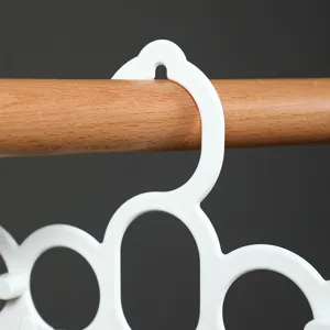 Multifunctionele witte plastic sjaal- en stropdas hanger aan houten kledingroede