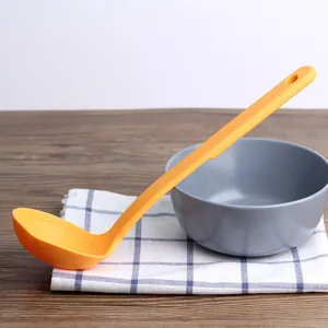 Orange heat-resistant soup ladle with long handle and pouring spout for cooking
