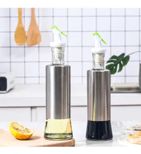 Coppia di bottiglie in vetro per olio e aceto con rivestimento in acciaio in una cucina.