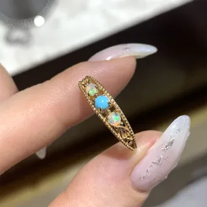 Macro detail of a vintage gold ring featuring turquoise and African opal stones