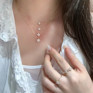 Close-up of four-leaf clover moissanite necklace and ring set in gold plated silver