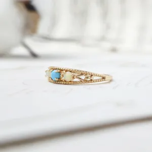 Close-up of vintage gold-plated silver ring with natural turquoise and opal stones