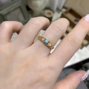 Detailed view of vintage gold-plated silver ring with turquoise and opal stones