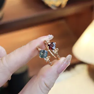 Close-up of S925 sterling silver rings with moss agate and garnet in bow design