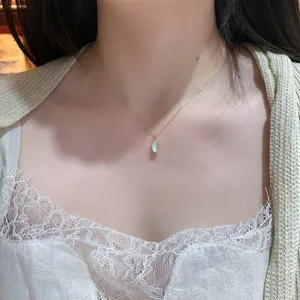 Close-up of elegant S925 silver necklace with green prehnite pendant on model neck.