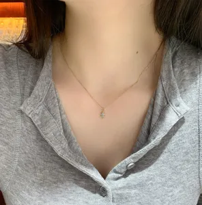 Primo piano di una collana in argento S925 dorato con ciondolo acquamarina