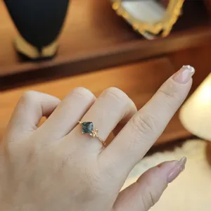 Detail view of a moss agate silver ring with a delicate golden ribbon design.