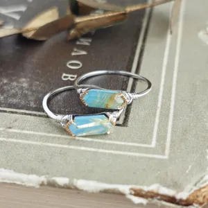 Macro detail of S925 silver wire-wrapped rings with hexagonal rutilated turquoise stones