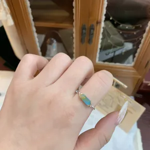 Detailed view of a gold-plated silver ring featuring turquoise and rutilated quartz