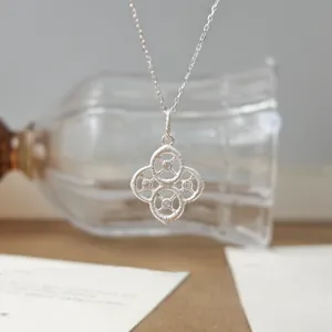 Vue détaillée du pendentif en argent S925 vintage avec motif dentelle ajourée