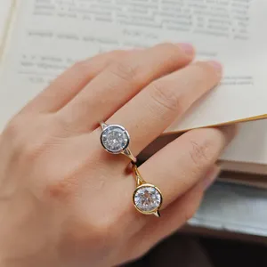 Nahaufnahme von zwei eleganten rund gefassten funkelnden Edelsteinringen an einem Handmodell