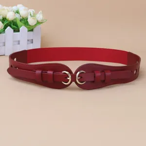 Dettaglio della cintura elastica rossa con eleganti fibbie doppie e decorazioni.