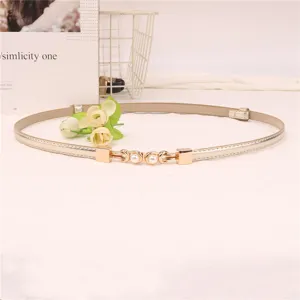 Gedetailleerd smalle gouden lederen riem met metalen parelgesp, chic minimalistisch accessoire.