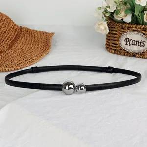 Detailed view of women's black thin belt with dual silver spherical buckles for dresses.