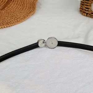Detailed view of women thin black belt with silver metal buckle, dress waist chain accessory.