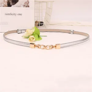 Gedetailleerde close-up van de slanke zilveren lederen riem met elegante gouden gesp.