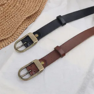 Detailed view of women's genuine leather belt with vintage brass buckle, elegant and slim style.
