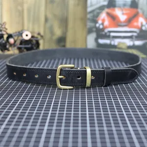 Black genuine leather belt detail shot featuring a vintage brass buckle and neat stitching.