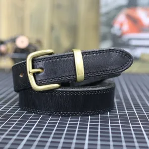 Close-up detail of black leather belt with metal buckle, vintage style, fine stitching.