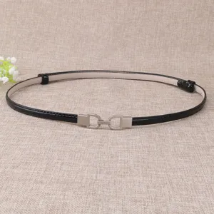 Ceinture fine femme en cuir vernis noir avec boucle en métal argenté élégante.