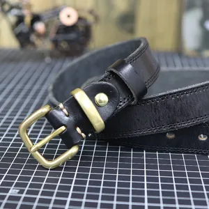 Black genuine leather belt detail close-up, vintage brass metal buckle and neat stitching.