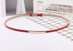 Ceinture fine en cuir vernis rouge pour femme avec boucle dorée élégante et chic.