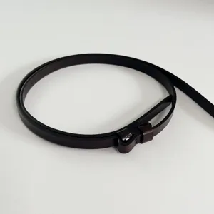 Close-up detail of a slim dark brown leather belt, showing minimalist design and texture.