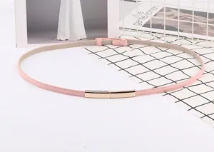 Ceinture fine rose tendance pour femme avec boucle métallique dorée, chaîne de taille chic.