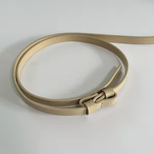 Detailed shot of a sleek minimalist beige thin leather belt, perfect for dresses and sweaters.