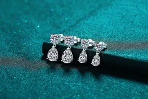 Elegant S925 silver pear-shaped moissanite drop earrings on a shimmering teal surface