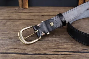 Close-up detail of women's genuine leather belt featuring solid brass buckle and neat stitching.