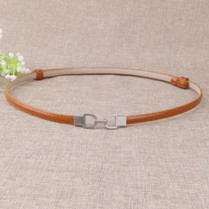 Vue détaillée d'une fine ceinture en cuir pour femme avec boucle en métal argenté.