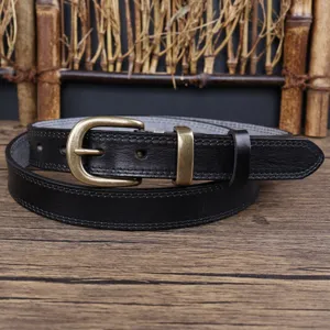 Detail shot of a black genuine leather women belt with vintage metal buckle on rustic wood.