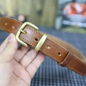 Brown genuine leather women belt with metal buckle, casual vintage style detail shot.