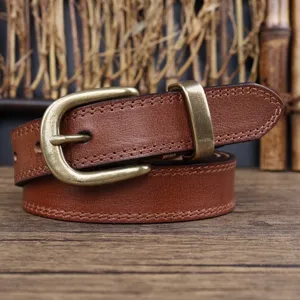 Brown genuine leather belt detail shot featuring vintage brass buckle and delicate stitching.
