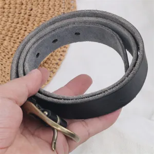 Close-up detail of women's black genuine leather belt with antique copper pin buckle.