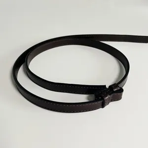 Close-up detail of the dark brown thin leather belt, showcasing fine stitching and smooth texture.