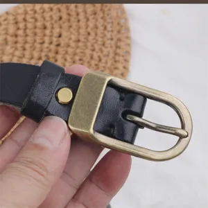 Detailed view of women genuine leather belt featuring classic antique brass pin buckle and black strap.
